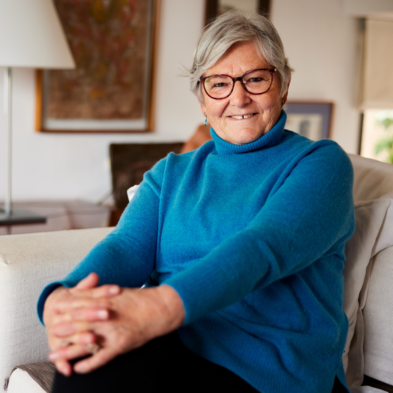 Co Own for Over 55s customer smiling on sofa 1380x1380px