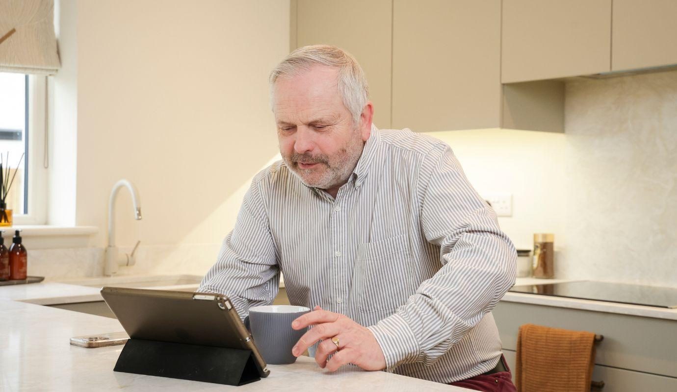 Man using propped-up tablet on kitchen counter