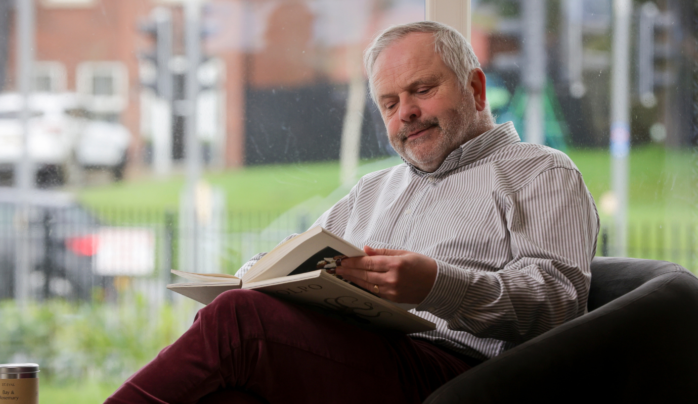 Eugene reading in front window 1380x800px