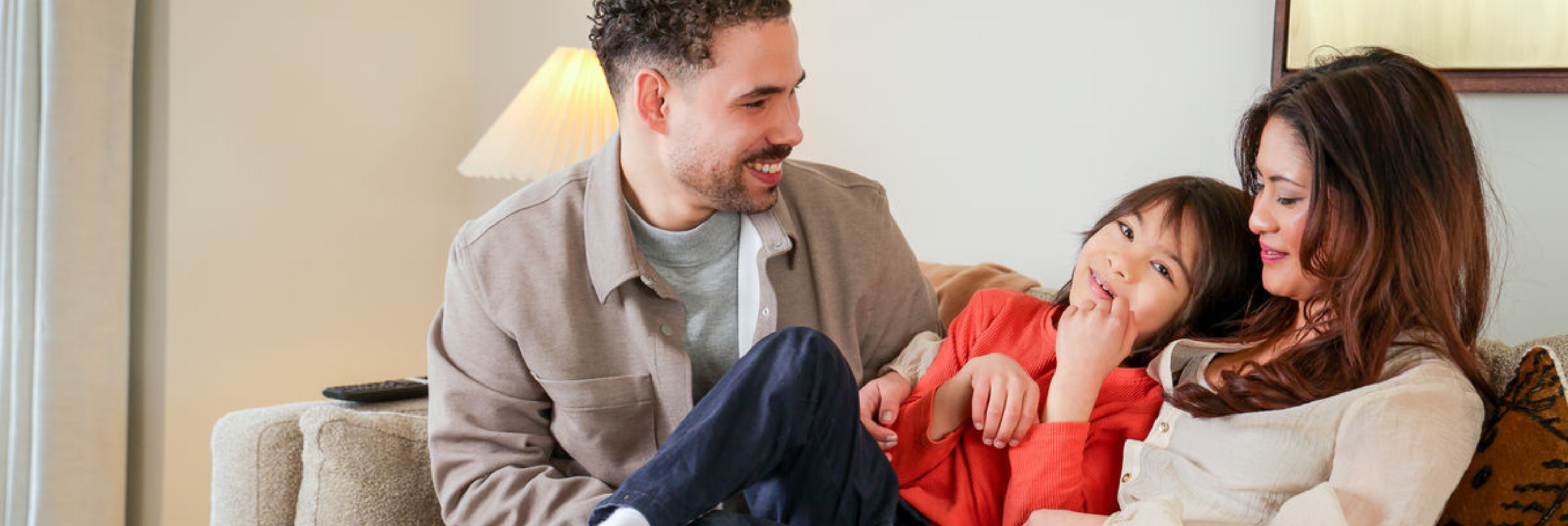 April lionel miguel cuddling on living room sofa 2980x1000px